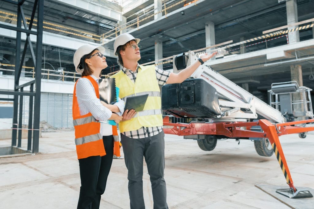 Woman engineer and man builder at construction site. Building, development, teamwork